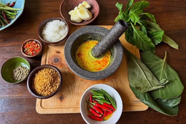 Making Balinese bumbu spice paste during a cooking class in a Bali villa